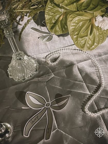 A detail of the elegant table decor, with a custom-designed bow-shaped place card and strings of pearls.