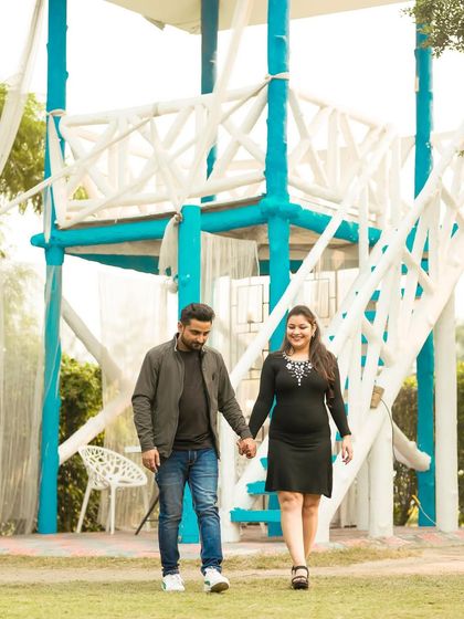 A relaxed walking shot of a couple hand-in-hand at an outdoor location, capturing a simple and sweet moment.