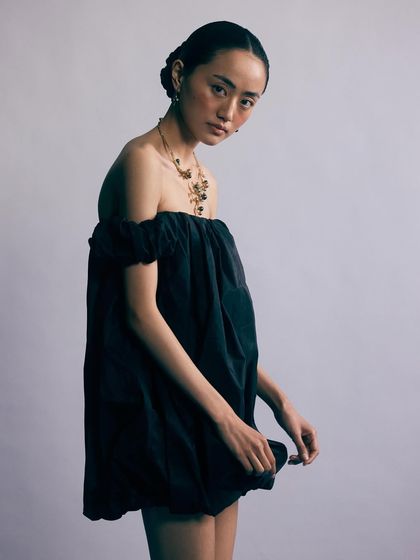 A moody shot from the same series. The off-shoulder dress beautifully frames the collarbones and draws attention to the statement necklace.
