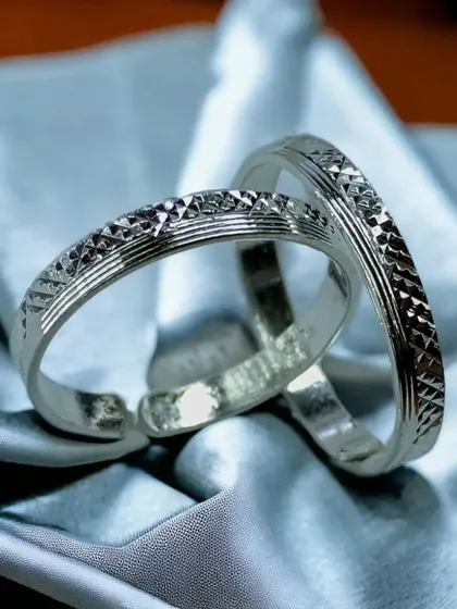 A pair of classic silver toe rings with a simple, etched pattern. These adjustable rings are a traditional and essential part of Indian bridal and everyday wear.
