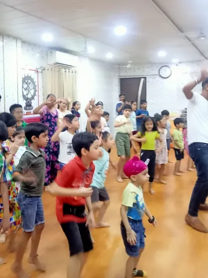 Our kids' fitness classes are all about joyful movement. An instructor leads a group of enthusiastic children in an energetic dance routine during our summer camp, making exercise feel like a party.