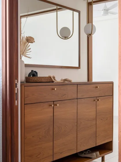 The 'Marshall' shoe cabinet, featuring curved edges and brass knobs. We added a practical bottom shelf for quick access to everyday slip-on footwear.