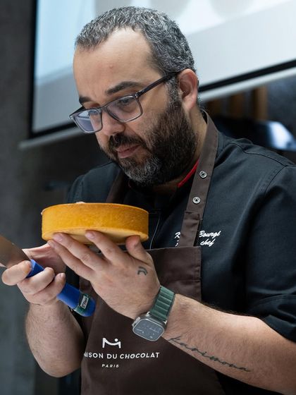 Chef Karim Bourgi inspecting the texture and crumb of a freshly baked cake before assembly.