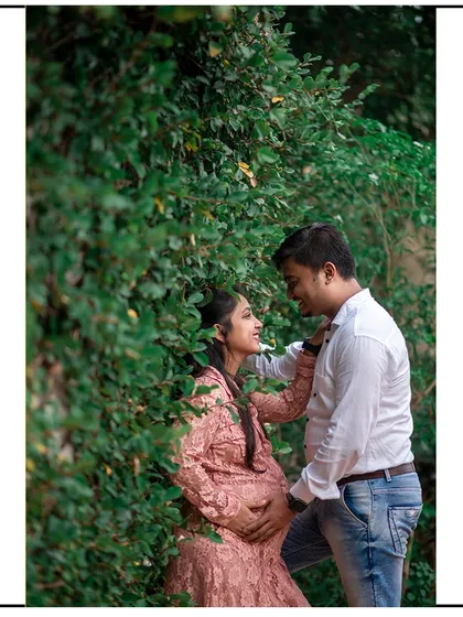 A quiet, intimate moment for the couple, nestled among the leaves of a green wall.