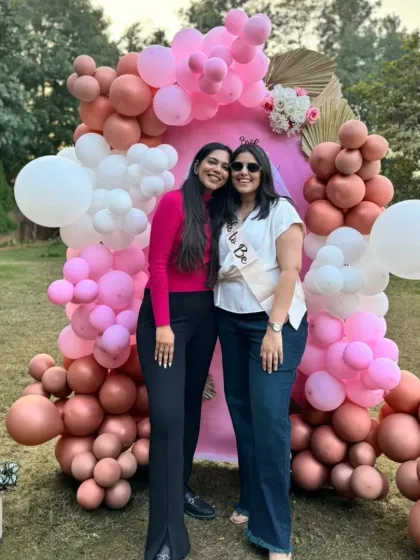 Two friends posing at the outdoor 'Miss to Mrs' bridal shower. The decor adds a celebratory feel to the garden party.