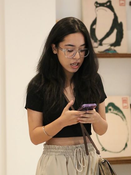 A performer reading her piece from her phone at our 'Chai & Poetry' session. We welcome all styles of performance, focusing on the power of the words themselves.