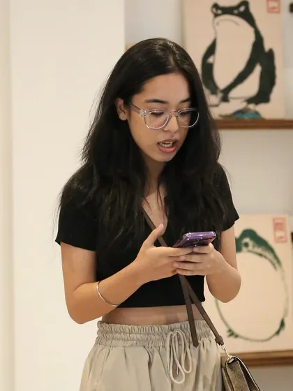 A performer reading her piece from her phone at our 'Chai & Poetry' session. We welcome all styles of performance, focusing on the power of the words themselves.