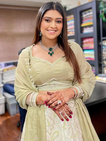 Simple, elegant makeup for a pre-wedding function. This look features clean skin, defined brows, and a neutral lip, allowing her natural beauty and the intricate henna to shine.