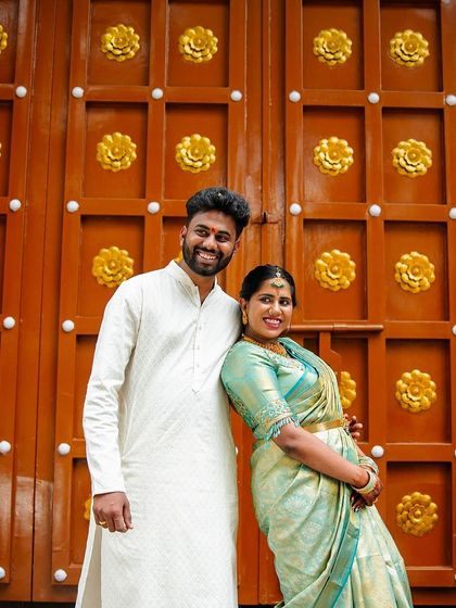 Another joyful portrait of an engaged couple in front of a traditional golden door, capturing their happiness and anticipation.