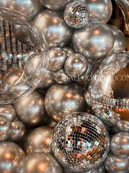 Detail shot of the silver balloon clusters and disco balls. I mix different textures and reflective surfaces to create a dynamic and visually interesting display.