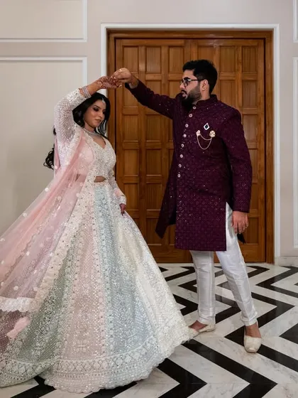 A graceful dance pose. This shot captures the elegance of the couple's coordinated outfits and the beautiful chevron-patterned floor of the venue.