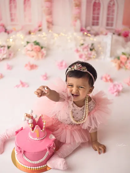 She came to melt my heart! This little princess had so much fun during her royal first birthday cake smash, and her joyful expression is absolutely priceless.