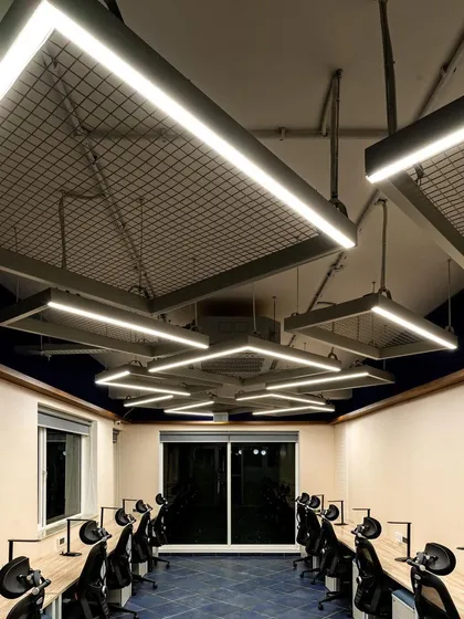 This view shows how the geometric light fixtures create a cohesive and dynamic ceiling-scape. The design ensures that every workstation receives consistent, high-quality illumination, promoting focus and well-being.