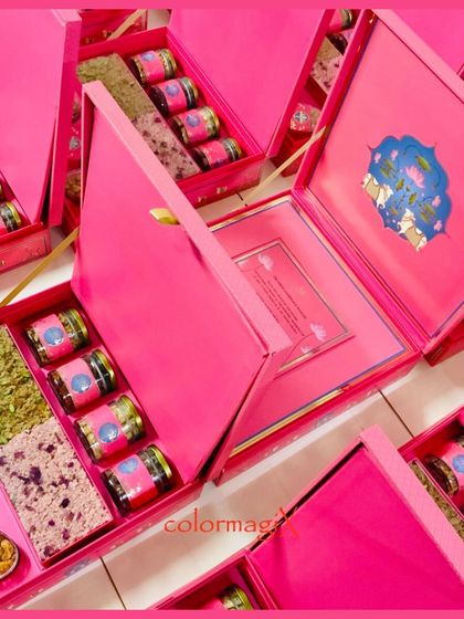 A display of multiple pink Pichwai-themed invitation boxes, ready for dispatch. This shows our capability to produce high-quality, customized invitations in bulk.