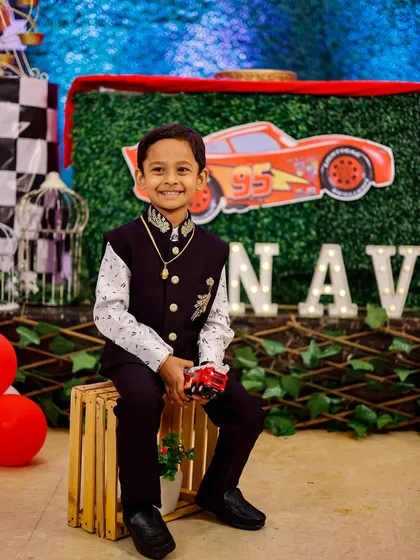 The birthday boy posing with his favorite toy car in front of his party's themed backdrop. I always capture the special details you've planned.