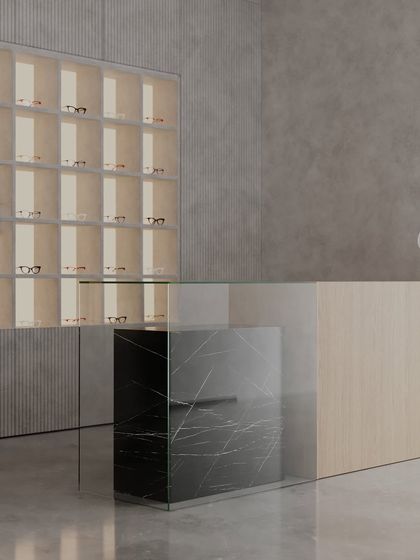 A different angle of the clinic's reception, showing the interplay of textures. The smooth concrete floor, ribbed wall panels, and warm wood create a tactile experience that is both minimalist and aesthetically rich.