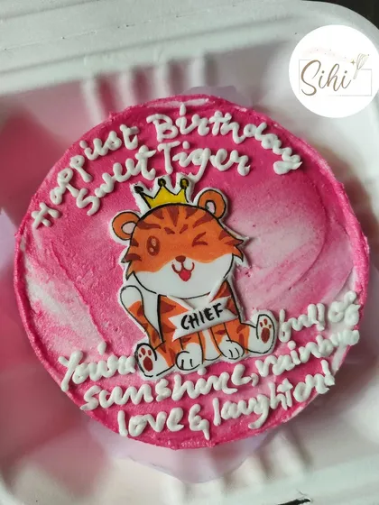 A cheerful and encouraging bento cake design. It features a cute cartoon tiger with a crown and a sash that says "CHIEF," surrounded by a positive birthday message.