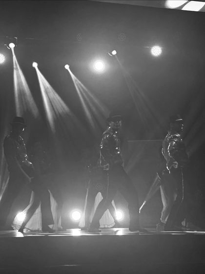 A black and white shot of our dancers in formation, creating a powerful and classic stage picture. We can bring this level of professionalism to your wedding event choreography.
