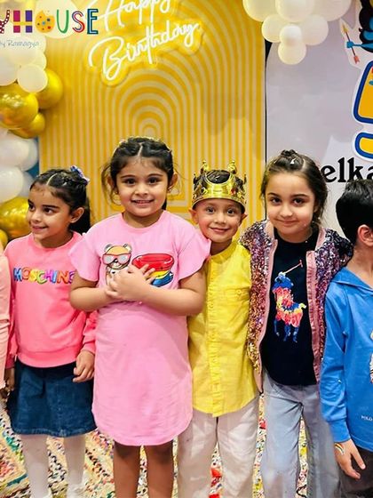 The birthday boy, wearing a crown, poses with his friends at his unique and cultural Ramayan-themed party.