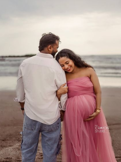 A moment of quiet connection with the ocean behind them. This pose is full of peace and love, perfectly capturing the feeling of waiting for their little one.