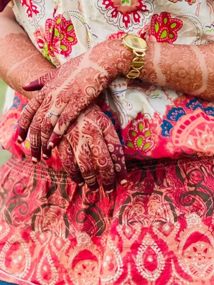 The rich, warm tone of this henna stain looks beautiful against the client's colorful outfit. It’s a testament to the quality of organic henna.