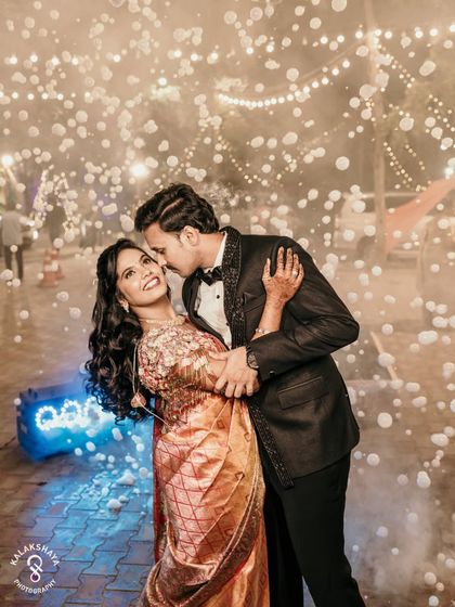 A romantic reception portrait, with the couple surrounded by bubbles and fairy lights.