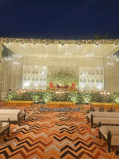 This elegant stage setup combines a lush floral wall with intricate traditional architecture and soft lighting. It’s a perfect example of how we create a sophisticated and romantic backdrop for your most important moments.