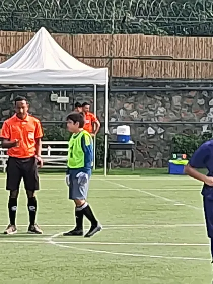 The referee and our goalkeeper during a break in play. Match officials are a part of the game, and we teach our players to always show respect.