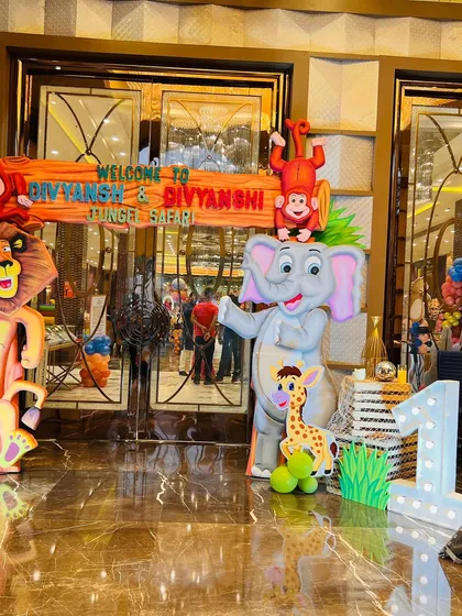 A grand entrance for a jungle safari party with large, friendly lion and elephant cutouts to greet guests.
