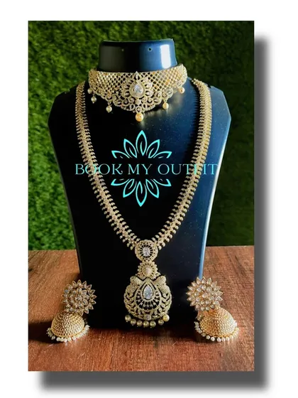For a more modern reception or party look, I offer sets like this one. It features a beautiful choker and a matching long necklace studded with brilliant white stones that look just like diamonds, paired with elegant jhumkas.