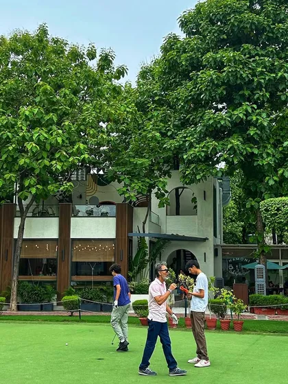 Friends enjoying a relaxed putting session in front of the cafe, making for a perfect weekend afternoon.