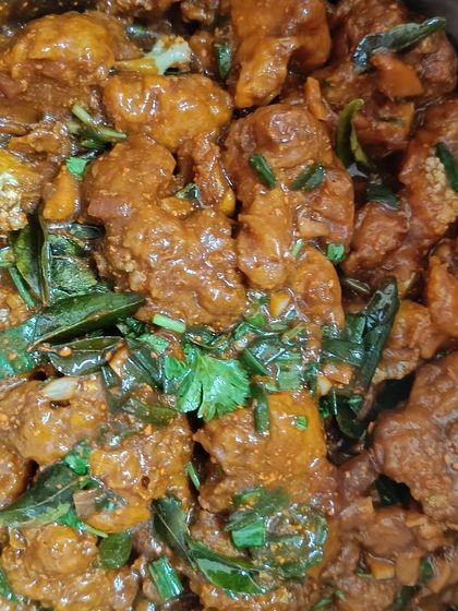The finished Gobi 65, tossed in a spicy and tangy sauce with curry leaves and fresh herbs. It's crispy on the outside and tender on the inside.