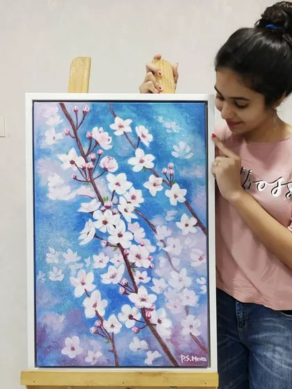 Me with my finished magnolia blossom painting. I love how the soft, delicate flowers stand out against the textured blue background.