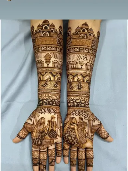 This design tells a story of a royal wedding, with a varmala scene on the palms and the iconic Taj Mahal on the forearms. The couple's initials, 'AM', are subtly woven into the pattern.