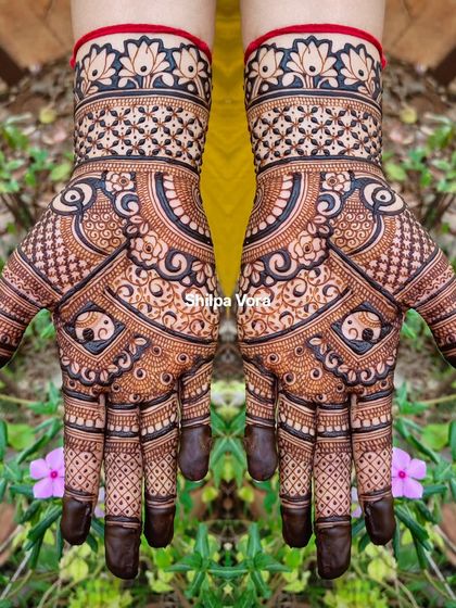 A symmetrical design with elephant motifs and a lotus cuff, set against a vibrant green background.