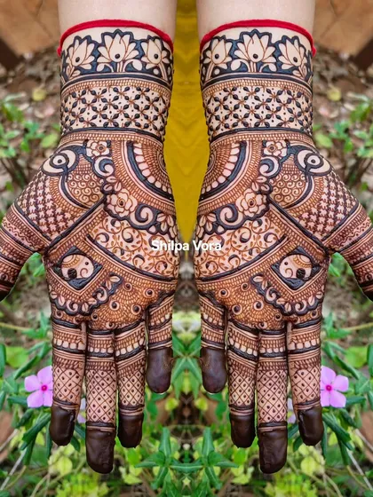 A symmetrical design with elephant motifs and a lotus cuff, set against a vibrant green background.