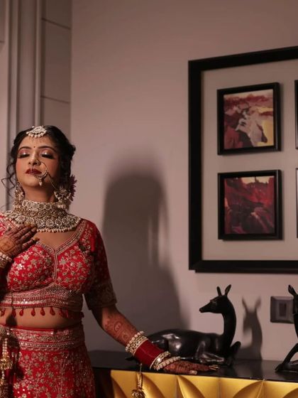 My bride Ritika, looking so elegant and royal. The soft, warm lighting complements her skin and her red outfit.