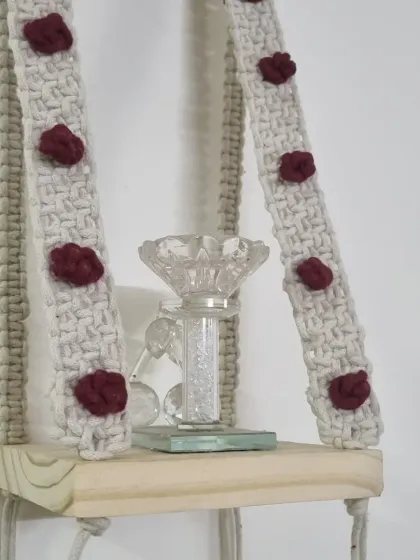 My macrame wall shelf is a lovely way to display small decor items, like this crystal candle holder. The straps are decorated with maroon berry knots.
