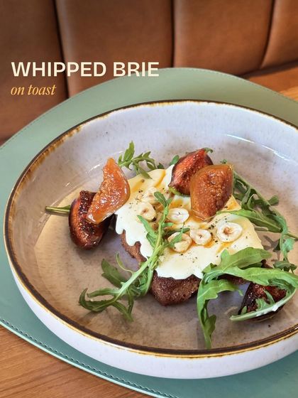Our Whipped Brie on Toast, a simple yet elegant dish with creamy brie, sweet macerated figs, and crunchy hazelnuts on sourdough.
