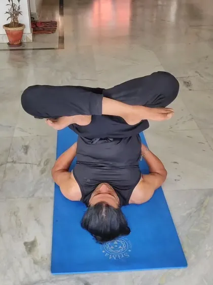 A student practices Urdhva Padmasana in Sarvangasana (Upward Lotus in Shoulder Stand). I guide students through advanced inversions, focusing on safety and proper alignment.