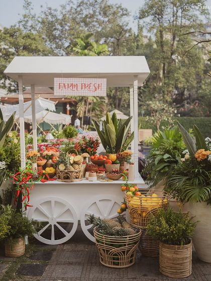 A 'Farm Fresh' cart filled with colorful fruits and vegetables serves as both a decor piece and a healthy snack station.