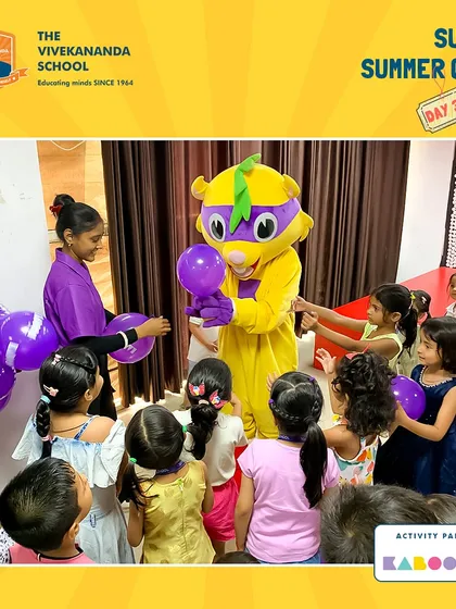 Super K helps hand out balloons at a summer camp event, creating a playful and engaging atmosphere for all the young campers.