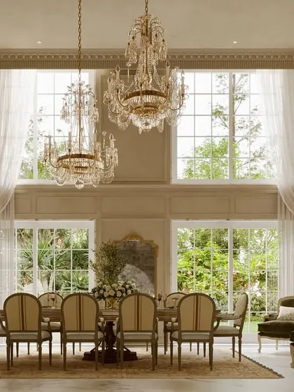 This double-height dining area is a celebration of scale and grandeur. I designed this space with soaring ceilings, intricate wall mouldings, and large crystal chandeliers to create an environment that feels both impressive and inviting for gatherings.
