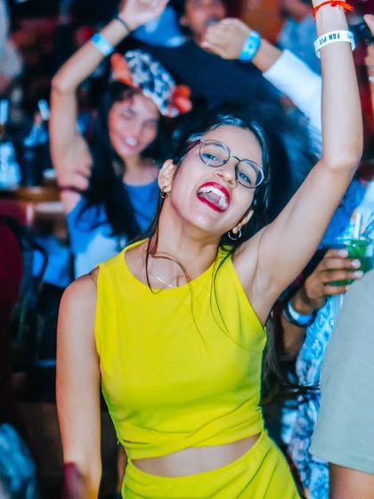 A guest in a bright yellow top, full of life and energy. The crowd is always as vibrant as the music.