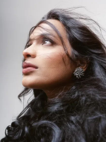 A creative portrait where the model looks upward, with her hair blowing in the wind. The angle and movement create a sense of hope and contemplation.