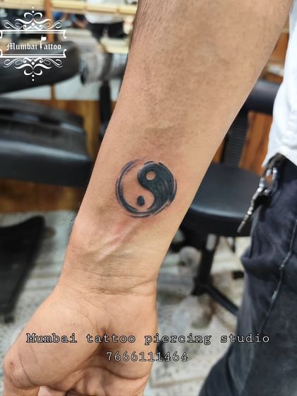 A yin-yang tattoo with a brushed, ink-wash style. This gives the classic symbol of balance and duality a more organic and artistic feel.