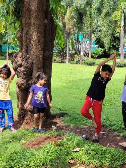 Finding balance together during an outdoor class. Practicing tree pose next to a real tree is a perfect way to connect with nature and our own stability.
