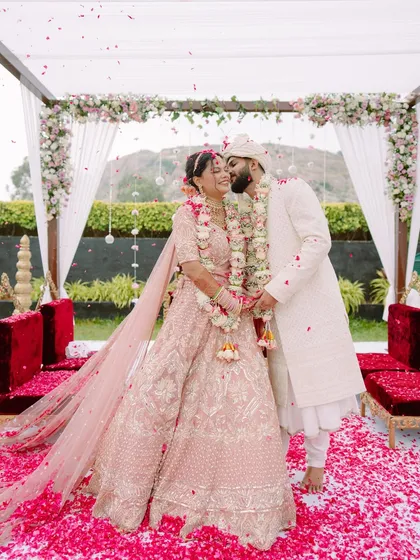Pure elation under a shower of petals. This is the peak of the celebration, a vibrant, joyous moment from a beautiful North Indian wedding ceremony that we captured in all its colorful glory.