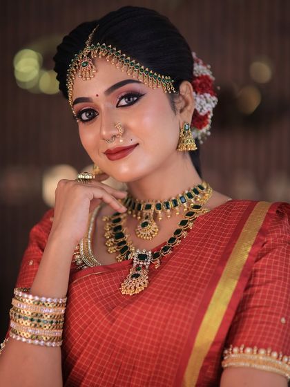 Model Swetha in a red checked silk saree. This traditional drape is perfect for showcasing classic South Indian bridal looks for catalogues or campaigns.