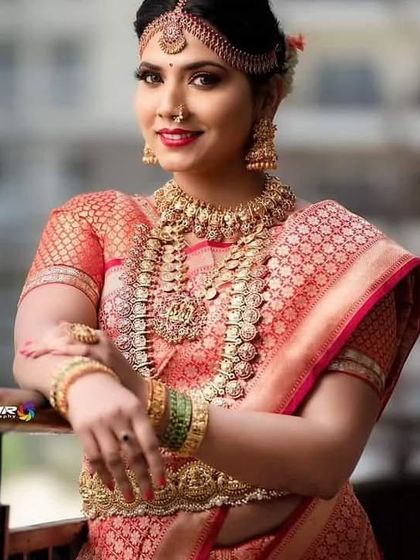 A beautiful bride in a pink saree adorned with our classic Kasu Mala and temple jewellery set. This is a perfect look for a Muhurtham ceremony.